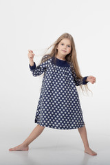 Fototapeta premium The happy girl in a blue polka dots dress, isolated on a white background