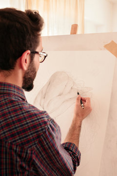 Artist drawing on a canvas at home