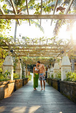 couple kissing while walking over bridge