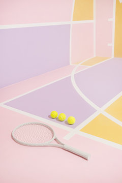 Tennis balls and racket on colorful course.