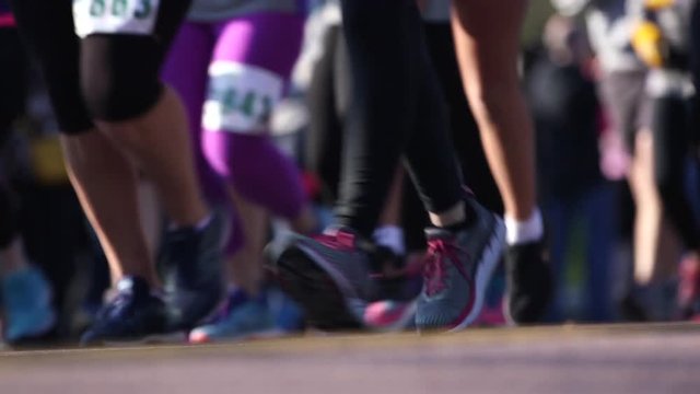 Low angle, people run in marathon
