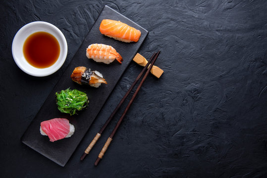 Set of sushi on dark stone table. Top view