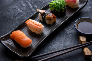 Set of sushi and maki on dark stone table. Top view with copy space