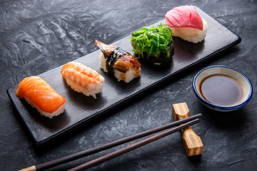 Set of sushi and maki on dark stone table. Top view with copy space © Hyper Bee