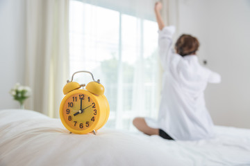 Closeup yellow clock on woman waking