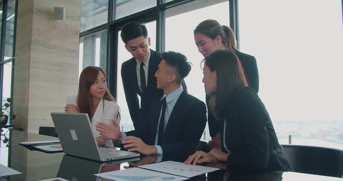 business people  looking at the laptop computer and talking during meeting