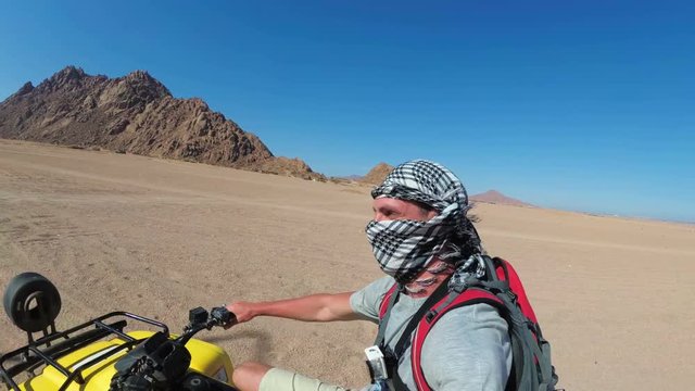 Man is Riding a Quad Bike in Desert of Egypt and Shooting Himself on an Action Camera