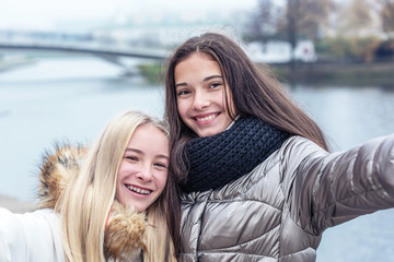 Fototapeta premium young attractive teen girls laugh while taking selfie together