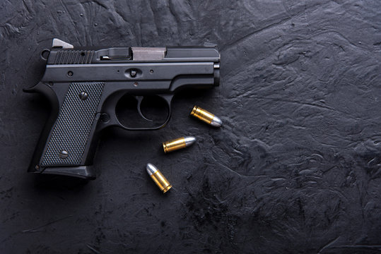Gun with tablet on dark background.