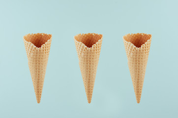 Set of three empty crisp ice cream cones on green background, mock up for advertising, design, menu, summer food.