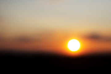 Abstract sunset light background texture. Blur the sun in dark sky.