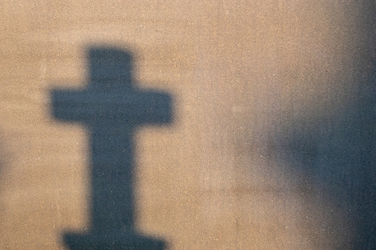 Cemetery reflection on a granite tombstone. The shadow of the crosses and tombstones.