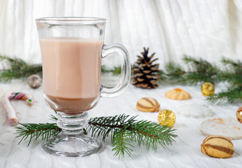 Obraz na płótnie Canvas Glass cup of hot cocoa with milk, candies and straw tube on background