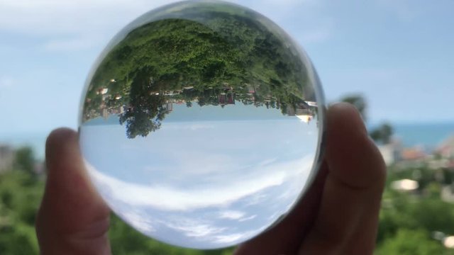 hand holding magic crystall ball over beautiful nature landscape, travel concept