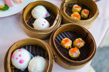 Chinese bun with minced pork and Dim sum, traditional Chinese dumplings, in bamboo steamer basket