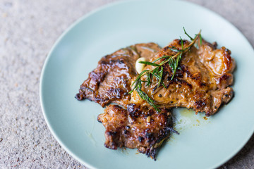 Round plate with grilled beef steak and rosemary