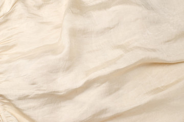Soft smooth beige silk fabric background. Fabric texture.