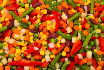 Sliced vegetables, corn, beans, peas, carrots, sweet peppers background.