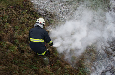 Feuerwehrmann löscht Brand mit einem Feuerlöscher