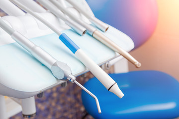 Stomatological instrument in dentists clinic. Tools drill, treat a dentist on white blue background.