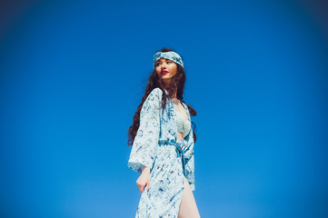 A young beautiful woman in beachwear and a ribbon on her head