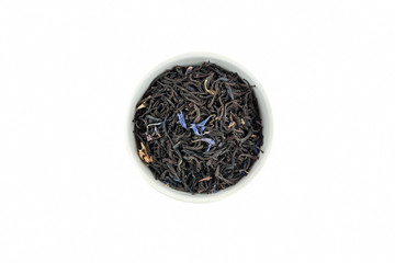 Dry black tea with blue flowers leaves in white bowl, top view
