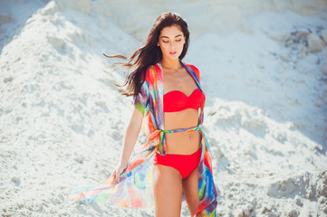 Beautiful sexy woman summer red swimwear posing on the sand 