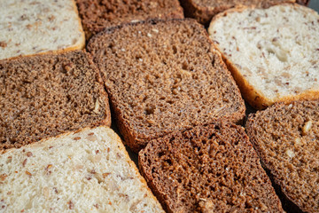 Close-up view of wholmeal bread slices, pattern effect. Whole-grain bread with visible detailed texture, diverse types