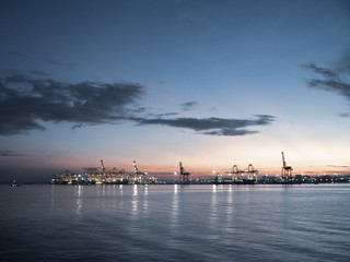 Fototapeta na wymiar Shipping cranes at a port by the sea looking like metal giraffes