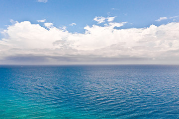 Obraz premium Seascape with clouds by day, view from above. Big white clouds over the sea.