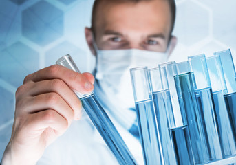 Portrait of concentrated male scientist working with reagents in laboratory
