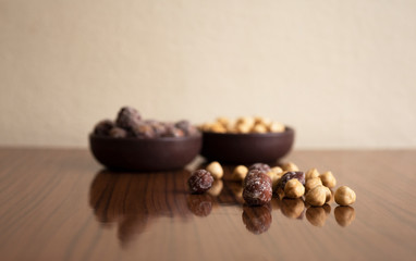 Hazelnuts, filbert in burlap sack and in brown bowl on rustic wooden table. heap or stack of hazelnuts. Hazelnut background, healty food