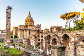 Fototapeta premium Roman Forum with Church of Santi Luca e Martina on sunny summer morning. Antique ruins in Rome, Italy