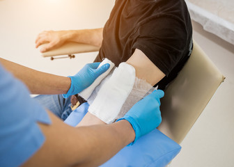 Nurse dressing wound for patient's hand with burn injury