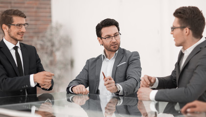 business colleagues are discussing something sitting at the office table