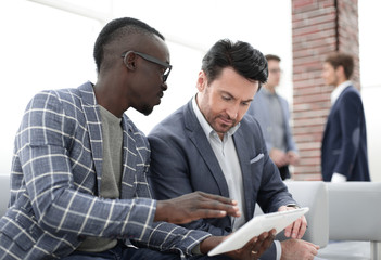 Obraz premium two business partners use a digital tablet.
