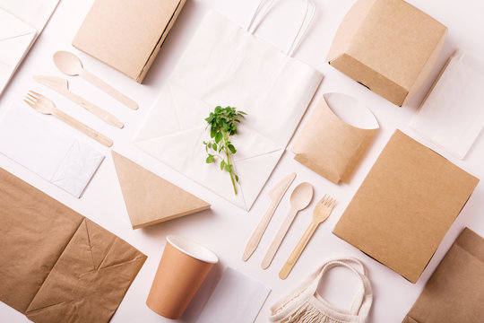 Catering and street fast food paper cups, plates and containers. Eco-friendly food packaging on white background with copy space. Flat lay. Top view. Carering of nature and recycling concept.