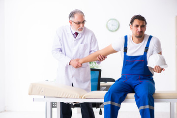Obraz premium Young male contractor visiting old doctor 