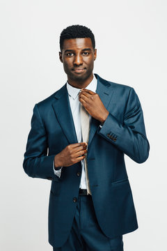 Portrait of a confident man in business suit, fixing tie