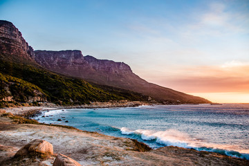 Naklejka premium Chapman's Peak Drive Through the Mountains in Cape Town at Sunset Next to the Sea with Crashing Waves in South Africa
