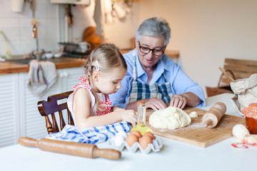 Obraz na płótnie Canvas Grandmother and girl making cake
