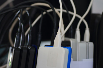 Small portable hard drives in stack connected to rear PC backup digital computer data. external...