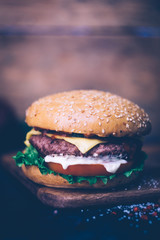 Home made Burger (cheeseburger) with beef on a wooden background. Classic home made Burger. Close up, copy space.