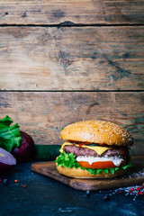 Home made Burger (cheeseburger) with beef on a wooden background. Classic home made Burger. Close up, copy space.