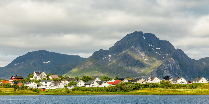 Norwegian houses and cottages at the lake with mountain in the background, Leknes, Vestvagoy Municipality, Nordland county, Norway