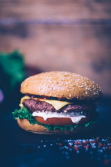 Home made Burger (cheeseburger) with beef on a wooden background. Classic home made Burger. Close up, copy space.