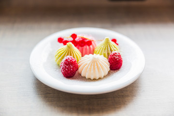 Close-up of the yummy meringue with the fruits in the plate indoors