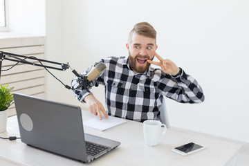 Blogger, streamer and people concept - Funny young man DJ working on the radio