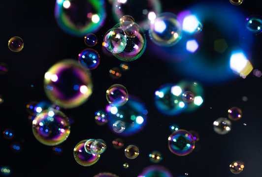 beautiful rainbow colorful of soap bubbles floating on black background.