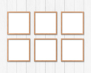 Set of 6 square wooden frames mockup hanging on the wall. Empty base for picture or text. 3D rendering.